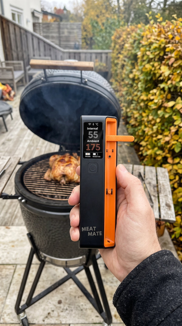 A brisket in butcher paper with the MEAT MATE probe, handled in leather grill gloves